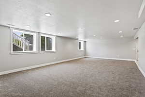 Spare room featuring a textured ceiling and carpet flooring