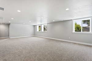 Spare room with carpet, a healthy amount of sunlight, and a textured ceiling