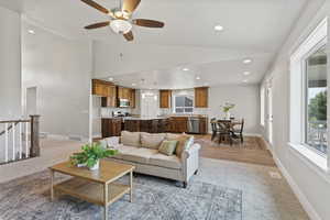 Living room featuring high vaulted ceiling, ceiling fan, and hardwood / wood-style floors