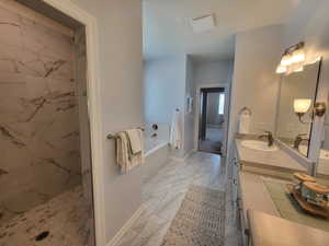 Bathroom with tile floors, vanity with extensive cabinet space, and independent shower and bath