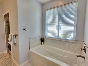 Bathroom with tile flooring and a bathtub