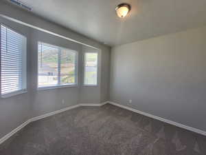 Carpeted empty room with a textured ceiling