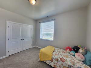 Carpeted bedroom with a closet