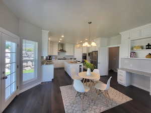 Dining space with sink, dark wood-type flooring, and an inviting chandelier