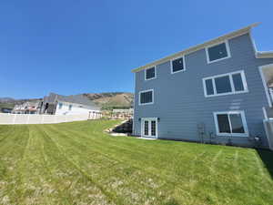 Rear view of property featuring a lawn and a mountain view