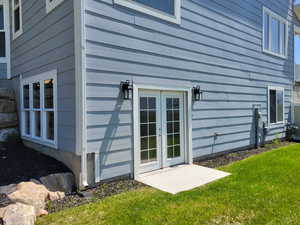 Entrance to property with french doors and a lawn