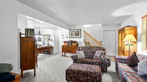 Carpeted living room featuring an inviting chandelier