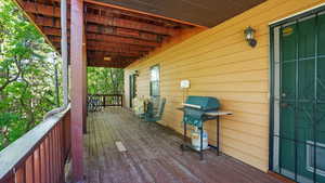 Wooden deck featuring area for grilling