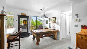 Carpeted office with a chandelier