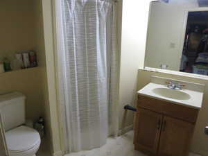 Bathroom featuring tile floors, toilet, and vanity