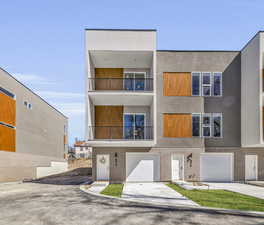 View of front facade with a garage and a balcony