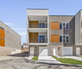 View of front of home featuring a garage and a balcony