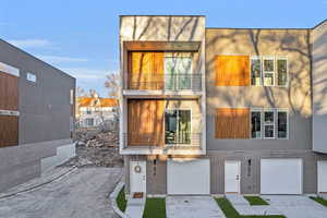 View of front facade featuring a garage and a balcony