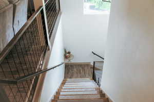 Stairs with a high ceiling and hardwood / wood-style flooring