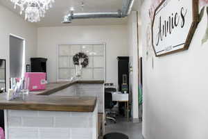 Office area featuring concrete flooring and a chandelier