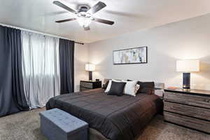 Bedroom featuring carpet, ceiling fan, and a textured ceiling