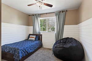 Bedroom featuring carpet, ceiling fan, and a textured ceiling