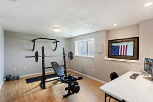 Workout room with a textured ceiling and light wood-type flooring