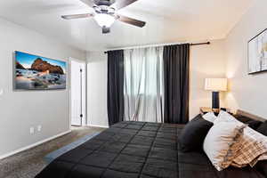 Carpeted bedroom featuring ceiling fan