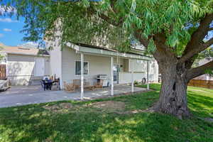 Rear view of house featuring a patio and a lawn