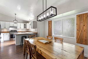 Dining space with wood-type flooring, sink, a textured ceiling, and lofted ceiling