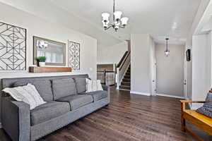 Living room with a chandelier and dark wood-type flooring