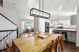 Dining space with sink, dark wood-type flooring, lofted ceiling, and a textured ceiling