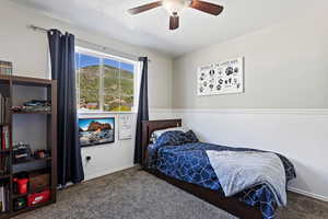 Bedroom with ceiling fan and dark carpet