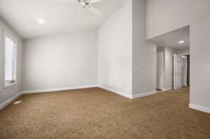 Carpeted spare room featuring ceiling fan