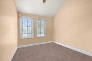 Carpeted spare room with vaulted ceiling