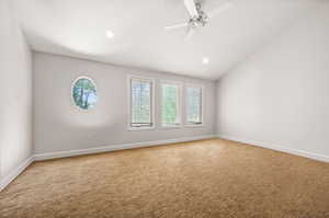 Unfurnished room featuring lofted ceiling, carpet, and ceiling fan