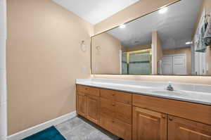 Bathroom featuring an enclosed shower, tile flooring, and vanity