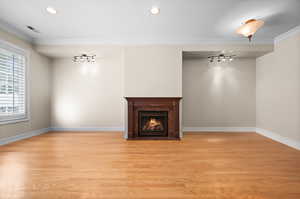 Unfurnished living room with crown molding, rail lighting, and light hardwood / wood-style flooring