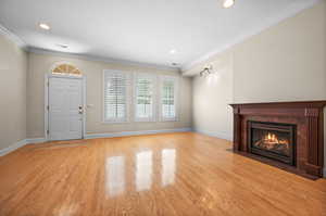 Unfurnished living room with light hardwood / wood-style floors and crown molding