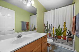 Full bathroom featuring tile flooring, shower / bath combination with curtain, vanity, and toilet