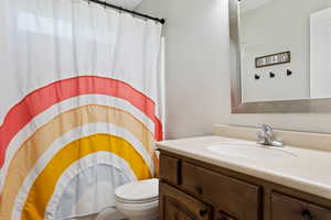 Bathroom with toilet and vanity with extensive cabinet space