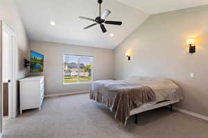 Carpeted bedroom featuring ceiling fan and lofted ceiling