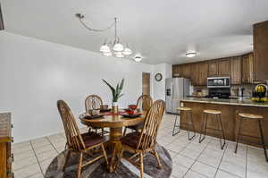 Dining area with a notable chandelier and light tile floors