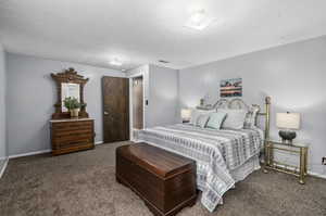 Bedroom featuring a textured ceiling and carpet flooring