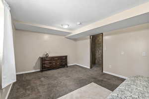 Bedroom featuring a textured ceiling and dark carpet