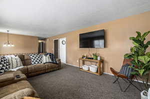 Living room featuring a chandelier and dark carpet