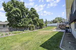 View of yard featuring a deck, central AC, and a patio