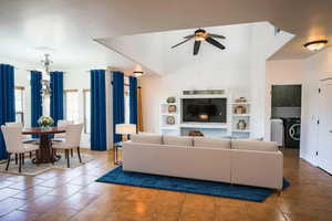 Tiled living room with ceiling fan, independent washer and dryer, and built in features