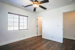 Unfurnished bedroom featuring ceiling fan and dark hardwood / wood-style flooring