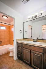 Full bathroom with vanity, toilet, and tiled shower / bath combo