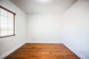 Empty room featuring dark hardwood / wood-style flooring