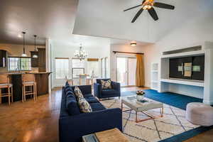 Living room with sink, ceiling fan with notable chandelier, and dark hardwood / wood-style flooring