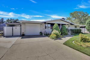 View of front of property with a garage and a front lawn