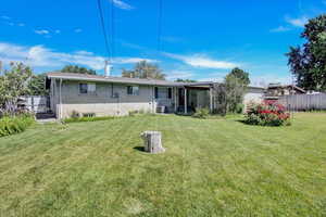 Back of property featuring a lawn and central air condition unit