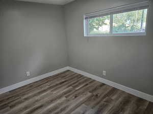 Empty room featuring dark hardwood / wood-style flooring